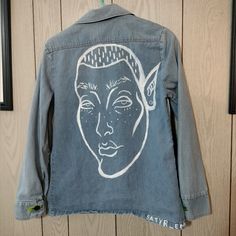 a denim jacket with an image of a woman's face on it