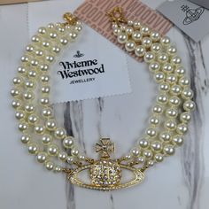 Vivienne Westwood Three Row Pearl Bas Relief Choker In Gold Revisits An Iconic Vivienne Westwood Collection, Dating Back Decades. Featuring Three Hand Knotted Rows Of Swarovski Pearls Meeting Together At A Branded Closure At The Back, The Necklace Is Complimented With The Signature Silver Gold Orb, Elegantly Placed To The Centre. 100% Authentic Brand New Comes With Gift Box, Gift Bag, And Dust Bag, Jewelry Cloth, Brand Card. Perfected In Gold Toned Brass, The Three Row Pearl Bas Relief Choker Co Iconic Vivienne Westwood, Vivienne Westwood Collection, Vivienne Westwood Pearl Necklace, Brand Card, Vivienne Westwood Jewellery, Saturn Necklace, Pearl Drop Necklace, Silver Diamond Necklace, Black Choker Necklace