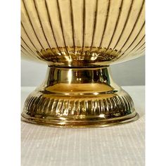 a golden bowl sitting on top of a white table