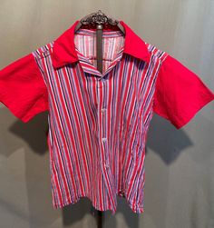 This is a fun vintage, little kid's shirt from the 40s or early 50s. No labels or tags. It is home sewn from a combination of feed sack fabric & cotton. The chest measures 34", please see measurements below.  The body is made from red, white, gray & blue striped feed sack fabric and the collar & sleeves are red cotton. It has short sleeves with stitched flat cuffs and a pointy collar. Buttons down the front & has a straight hemline. The shirt is in good condition. There is a repair around the se Vintage Red Camp Shirt With Camp Collar, Red Retro Shirt With Camp Collar, Retro Red Short Sleeve Camp Shirt, Retro Red Shirt With Camp Collar, Retro Summer School Tops, Retro Red Cotton Camp Shirt, Vintage Red Short Sleeve Camp Shirt, Red Collared Cotton Camp Shirt, Retro Red Cotton Shirt