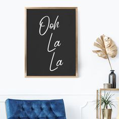 a black and white poster with the words oh la la on it next to a blue chair