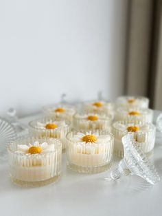 small cupcakes with yellow flowers on them are sitting on a white tablecloth