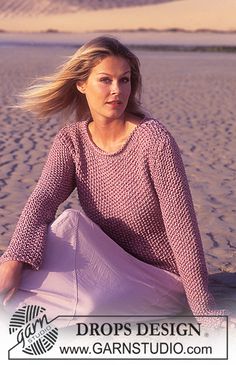 a woman sitting on top of a sandy beach