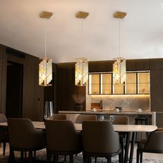 a dining room table and chairs with lights hanging from the ceiling