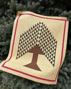 a quilt hanging from the side of a christmas tree with an image of a tree on it