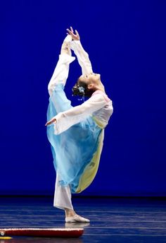 a woman in blue and white doing a dance pose