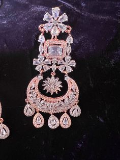 Rose Gold Gorgeous Handmade Statement Long Earrings in American Diamond and CZ stones. Chandbali Style. Item : Earring Set Color : Rose Gold Length of Earrings : 3.1 inches Width of Earnings - 1.5 inches (widest part)Shop Polices -- Final Sale, No Return, No exchange - Please note Jewelry is delicate and Fragile, please handle with care.- There can be little variation in the color due to screen resolution setting, phone display setting or anything else. Kindly do not hold us responsible.- No ret Luxury Hand Set Chandbali Jewelry, Luxury Chandbali Earrings For Eid, Luxury Traditional Hand-set Diamond Earrings, Luxury Chandbali Party Danglers, Luxury Diamond Jhumkas With Stone Work, Luxury American Diamond Chandbali Bridal Earrings, Elegant Rose Gold Earrings For Festive Occasions, Elegant Rose Gold Festive Earrings, Elegant Festive Rose Gold Earrings