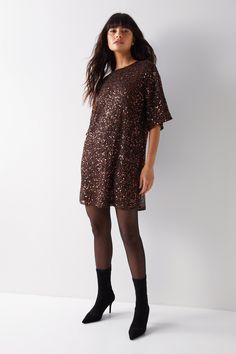 All-over sequin embellishments add glamorous texture   Relaxed, slouchy fit with batwing sleeves   Round neckline and straight hem for easy styling   Lined to prevent transparency   Lightweight, pull-on style with no fastenings  This sequin-embellished slouch tee shirt dress from Warehouse is an elegant choice for special occasions. The all-over sequins create a glamorous, textured look while the relaxed, batwing sleeve silhouette keeps the style effortlessly chic. Pair with sheer tights and heels for a refined evening ensemble. The round neckline and straight hem allow for versatile styling. With its pull-on design and lightweight lining, this dress offers an easy-to-wear option for your next formal event. Let the dazzling embellishments be the focus and keep the rest of your look mini Sequin T Shirt, Sequin T Shirt Dress, Wedding Guess Dress, Wedding Guess, Tights And Heels, Sleeve Silhouette, Friday Outfit, Loungewear Jumpsuit, Sheer Tights