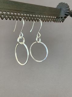 "Hand Forged Metal Jewelry | Silver Hoop Earrings, Fine Sterling Silver These round hoop earrings are perfect for everyday wear and would make a wonderful gift. We use only fine and sterling silver for all of our jewelry and findings, including our handmade earwires. Shaped and hammered for simplicity and elegance; then tumbled for strength and durability. Size is approximately 7/8\" x 1 7/8\". Our designs are each individually handcrafted and made to order.. because of this each design may have Nickel-free Sterling Silver Hoop Earrings For Everyday, Simple Sterling Silver Hoop Earrings For Everyday, Minimalist Sterling Silver Oval Hoop Earrings, Simple Hypoallergenic Dangle Hoop Earrings, Nickel-free Hoop Earrings For Everyday, Nickel Free Hoop Earrings For Everyday, Sterling Silver Open Circle Hoop Earrings For Pierced Ears, Everyday Small Silver Hoop Earrings, Small Hoop Sterling Silver Earrings With Lever Back