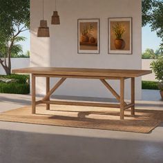 a large wooden table sitting in front of a white wall with two pictures on it