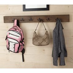 two purses are hanging on the wall next to a coat rack and jacket hanger