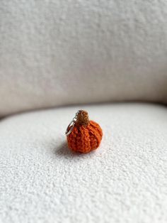 an orange crocheted pumpkin sitting on top of a white couch