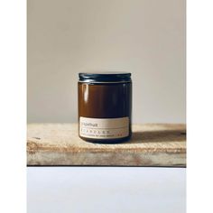 a jar of honey sitting on top of a wooden table next to a white wall