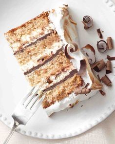 a piece of cake on a white plate with a fork next to it and mushrooms