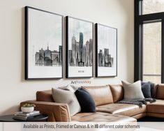 a living room with couches and pictures on the wall above them in front of a window