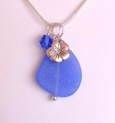 a blue sea glass necklace with a silver charm