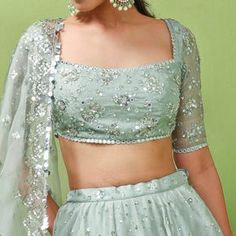 Elevate your style with our Mint Green Zardosi Lehenga Set. This captivating ensemble features a mint green organza lehenga adorned with splatter embroidery, complemented by a matching blouse intricately embellished with floral zardosi embroidery. Complete the look with the organza scalloped lace border dupatta. Customizable in any color (blue in video for reference), but we recommend pastel shades for an ethereal touch. Composition : Organza Care: Dry Clean Only and Vacuum Storage This product can be customised for sleeves, length of blouse and neckline Delivery : 4-6 weeks as the product is hand crafted. For more information and sizes please contact fabiliciousfashion@gmail.com or visit our Copenhagen studio. About the Designer : Step into the world of exquisite Indian wedding wear with Zardosi Lehenga, Green Organza Lehenga, Zardosi Embroidery, Organza Lehenga, Vacuum Storage, Indian Wedding Wear, Pastel Shades, Lace Border, Scalloped Lace