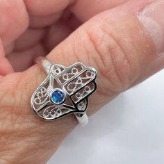 *  Sterling Silver Hamsa Tiny Blue Sapphire CZ Ring, Hand of God Ring, Religious Ring, Hamsa Promise Ring, Silver Ring, Statement Ring, Love Ring, Boho Ring, Eye Ring, 925 Stamped *  Hamsa is primarily used to protect its owner from the Ayin Ha'ra also known as The Evil Eye Protective talisman that brings good fortune, health and happiness *  Perfect gift idea for any occasion: birthday, anniversary, engagement, graduation, bridesmaid, Mother's Day, Valentine's Day, Christmas, promise. *  Your p Adjustable Blue Birthstone Jewelry, Blue Spiritual Open Ring Jewelry, Spiritual Blue Open Ring Jewelry, Blue Sapphire Spiritual Ring, Spiritual Blue Crystal Gemstone Ring, Adjustable Blue Sapphire Ring, Handmade Blue Birthstone Ring As Gift, Handmade Blue Birthstone Ring For Gift, Spiritual Blue Sapphire Ring