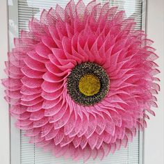 a pink flower is hanging on the front door