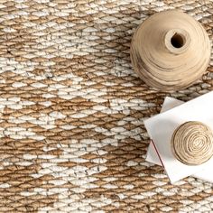 two spools of thread next to a piece of paper on a woven surface