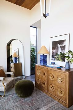 a living room with a large mirror and wooden furniture in it's centerpiece