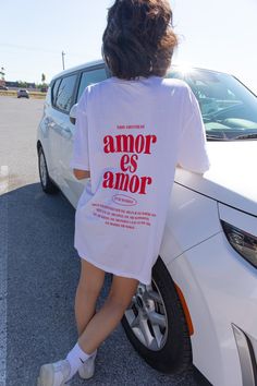 a woman sitting on the back of a white car