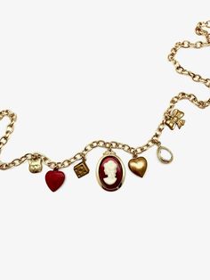 This charm necklace is the perfect mix of classic and trendy... made of mostly vintage charms on a vintage gold-plated chain, we can't even pick our favorite charm! 7 charms hang from this 18" vintage oval-cable chain: tiny brass cat face vintage powder-coated red heart vintage brass dice charm vintage glass/ gold plated cameo charm vintage brass puffy heart clear, natural quartz tear-drop shaped pendant, vermeil (18K gold plated) vintage brass bow Details: 18" in length, but can be clipped to w Vintage Metal Necklace With Logo Charm, Vintage Gold-tone Necklace With Logo Charm, Vintage Gold-tone Jewelry With Logo Charm, Vintage Metal Charm Necklace, Vintage Necklace With Logo Charm As Gift, Vintage Chain Necklace With Heart Charm For Gift, Elegant Gold-tone Charm Necklace With Vintage Charm, Vintage Metal Necklaces With Dangling Charms, Vintage Gold-tone Jewelry For Valentine's Day