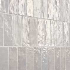 a white tiled wall with silver tiles on it