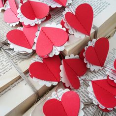 paper hearts are arranged on top of an open book