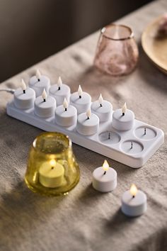 candles are arranged in rows on a table