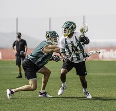 two lacrosse players are playing on the field