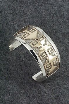 This vintage sterling silver & 14k gold fill bracelet was made by Navajo silversmith Dan Jackson. The back is signed Jackson and stamped 14k.Size: 5 3/8" (will fit a 6 1/2" wrist)Gap: 1 1/8"Length: 1 3/8"Free shipping on all orders! We ship with USPS and always include tracking. All orders ship within a day of payment.Returns are accepted up to 30 days after you receive your order. Just send us a message. Our shop offers cash back or store credit. The item must be returned in new condition. Southwestern Style Jewelry With Polished Finish For Anniversary, Southwestern Style Polished Jewelry For Anniversary, Southwestern Engraved Jewelry For Anniversary, Traditional Gold-colored Sterling Silver Bracelet, Traditional Gold Sterling Silver Bracelet, Indigenous Americans, Native Jewelry, Silver Jewelry Handmade, American Indian