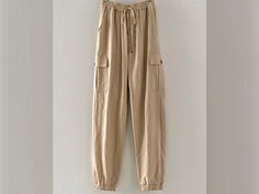 "Stay comfortable and stylish this summer with these premium quality mid rise jogger linen pants. Featuring an elastic waistband, adjustable drawstring, and cargo pockets, these pants are perfect for a beach vacation, lounge day, or resort cruise. Choose from the colors of Mint, Khaki, and White in sizes ranging from small to large. With real side pockets, you'll have a place to store your essentials while looking chic and fashionable. Upgrade your summer wardrobe with these must-have cargo line Casual Summer Cargo Pants With Drawstring, Summer Khaki Cargo Pants With Drawstring, Casual Cotton Cargo Pants For Vacation, Summer Relaxed Fit Cargo Pants With Drawstring, Casual Summer Cargo Pants For Loungewear, Summer Beige Drawstring Cargo Pants, Summer Linen Cargo Pants With Elastic Waistband, Beige Drawstring Cargo Pants For Spring, Summer Leisure Cotton Cargo Pants