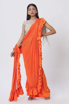 Orange pre-draped saree with ruffle detail and pearl embellishment on the border. Comes with pearl embellished blouse.
Components:2
Pattern:Embellishment
Type of Work:Pearl and Stone
Neckline:Boat
Sleeve Length:Sleeveless
Fabric:Lycra
Color:Orange
Other Details:
Mesh detail on the neckline
Tassel fringe detail
Closure: Blouse: Back zip; Saree: Side zip
Occasion:Party - Aza Fashions Designer Fusion Pre-draped Saree For Diwali, Festive Fusion Pre-draped Georgette Saree, Silk Party Saree With Ruffles, Silk Pre-draped Saree With Ruffles For Party, Silk Pre-draped Party Saree With Ruffles, Silk Party Pre-draped Saree With Ruffles, Pre-draped Georgette Saree With Pallu, Designer Georgette Pre-draped Saree With Ruffles, Silk Saree With Ruffles For Evening