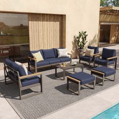 a set of patio furniture sitting next to a swimming pool