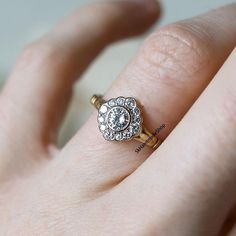 a woman's hand with a diamond ring on top of her finger and an engagement band