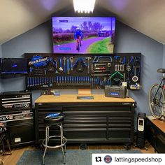 a garage with lots of tools on the wall and a flat screen tv above it