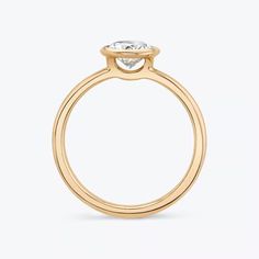 a yellow gold engagement ring with a round diamond on the top and side, against a white background