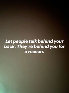 a person standing in front of a wall with a quote on it that says, let people talk behind your back they're behind you for a reason