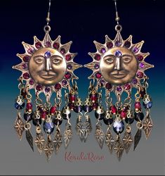 "These Celestial Boho Chandelier Earrings are made with large hand-antiqued brass Sun stampings richly decorated with crystal rhinestone 3'rd eyes and rays. Amethyst & Garnet Red crystal and glass beads and metal diamoond charms add to the whimsical design. Available in Posts, Clip-Ons or French Wires. -3 1/4\" Long(not including piercing) x 1 3/4\" Wide -0.3 oz. ea. *Comes Ready To Gift in Decorative Packaging *Each Pair is Made Just for You! Kerala Rose Pinterest page: https://www.pinteres Bohemian Sun Design Adjustable Earrings, Bohemian Sun And Moon Earrings For Festivals, Bohemian Sun And Moon Design Earrings For Festival, Bohemian Summer Jewelry With Sun And Moon Design, Bohemian Sun And Moon Design Jewelry For Summer, Bohemian Sun Design Earrings For Festival, Red Bohemian Jeweled Jewelry, Bohemian Red Jeweled Jewelry, Suns With Faces