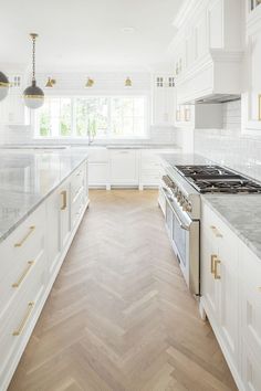 a kitchen with white cabinets and gold trimmings on the counter tops is pictured in this image