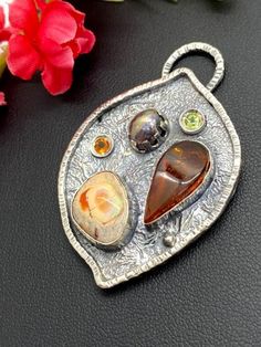 "Artisan Amber with Mexican Fire Opal pendant in sterling silver Hand-made Sterling Silver 925 Stones used: Baltic Amber, Mexican Fire Opal Purple Pearl, Peridot, Citrine Height - 2\", Width - 1 3/8\" Unique Handcrafted One-of a-kind Design Pendant Each Piece of Jewelry in my Collection is Absolutely One of a Kind! When you start wearing a piece of my jewelry you will fall in love with it more and more each day and feel that good Energy and Love that I pass into it while creating this piece of A Spiritual Sterling Silver Gemstone Pendant, Spiritual Sterling Silver Pendant Gemstone, Fusion Style Sterling Silver Gemstones, Handmade Sterling Silver Oval Pendant Gemstone, Artistic Sterling Silver Jewelry With Gemstones, Sterling Silver Multi-stone Oval Pendant Jewelry, Hallmarked Sterling Silver Pendant Gemstones, Artisan Silver Pendant Gemstones, Artisan Sterling Silver Pendant Gemstones