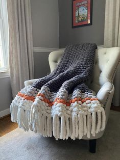 a white chair with a blanket on top of it