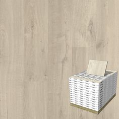 a white basket sitting on top of a wooden floor next to a box filled with papers