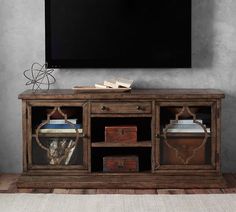 an entertainment center with a large flat screen tv mounted on it's sideboard