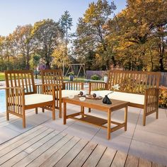 a wooden table sitting on top of a patio next to a swimming pool