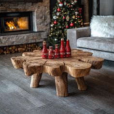 a wooden table topped with red bottles next to a christmas tree in a living room