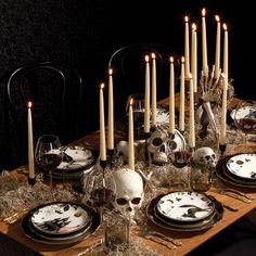 a table topped with plates covered in skulls and candles