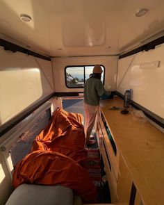 a man standing in the back of a truck next to a table with an orange sheet on it