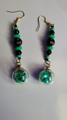 Green orb handcrafted earrings, with black and green beading Nickel-free Green Earrings For Party, Green Nickel-free Party Earrings, Nickel-free Green Beaded Earrings For Parties, Handmade Green Earrings For Party, Green Jewelry With Black Beads As A Gift, Green Jewelry With Black Beads For Gift, Green Resin Drop Earrings, Green Jewelry With Black Round Beads, Unique Green Beaded Earrings For Party